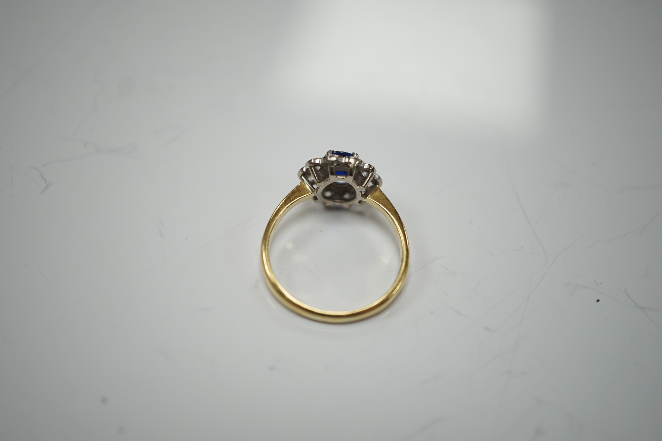 A modern 18ct gold, sapphire and diamond set circular cluster ring, size P/Q, gross weight 3.4 grams.